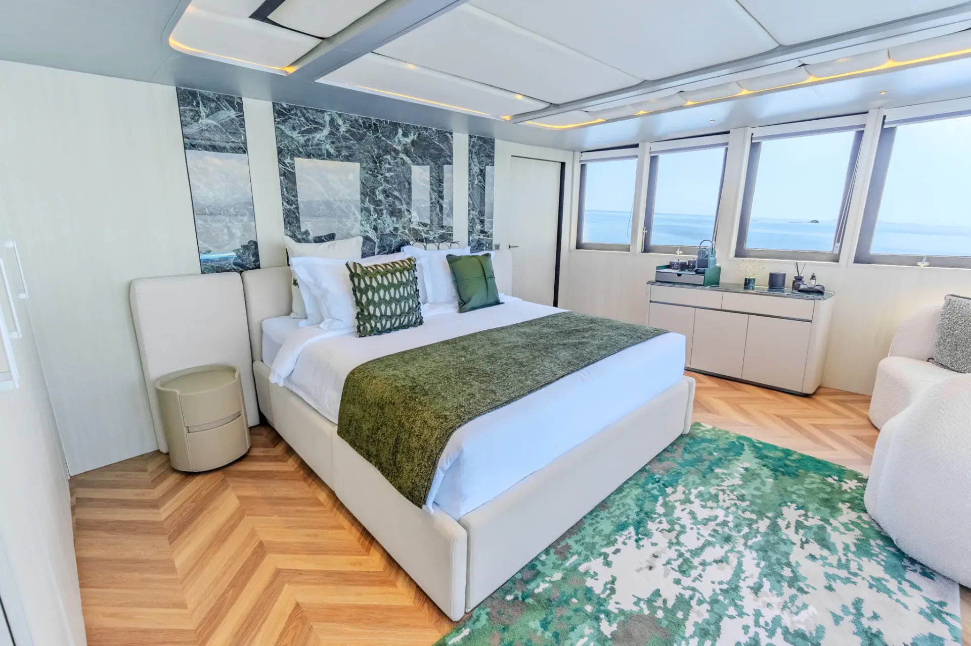 Master cabin on Kayra Phinisi with green marble headboard and sea-view windows