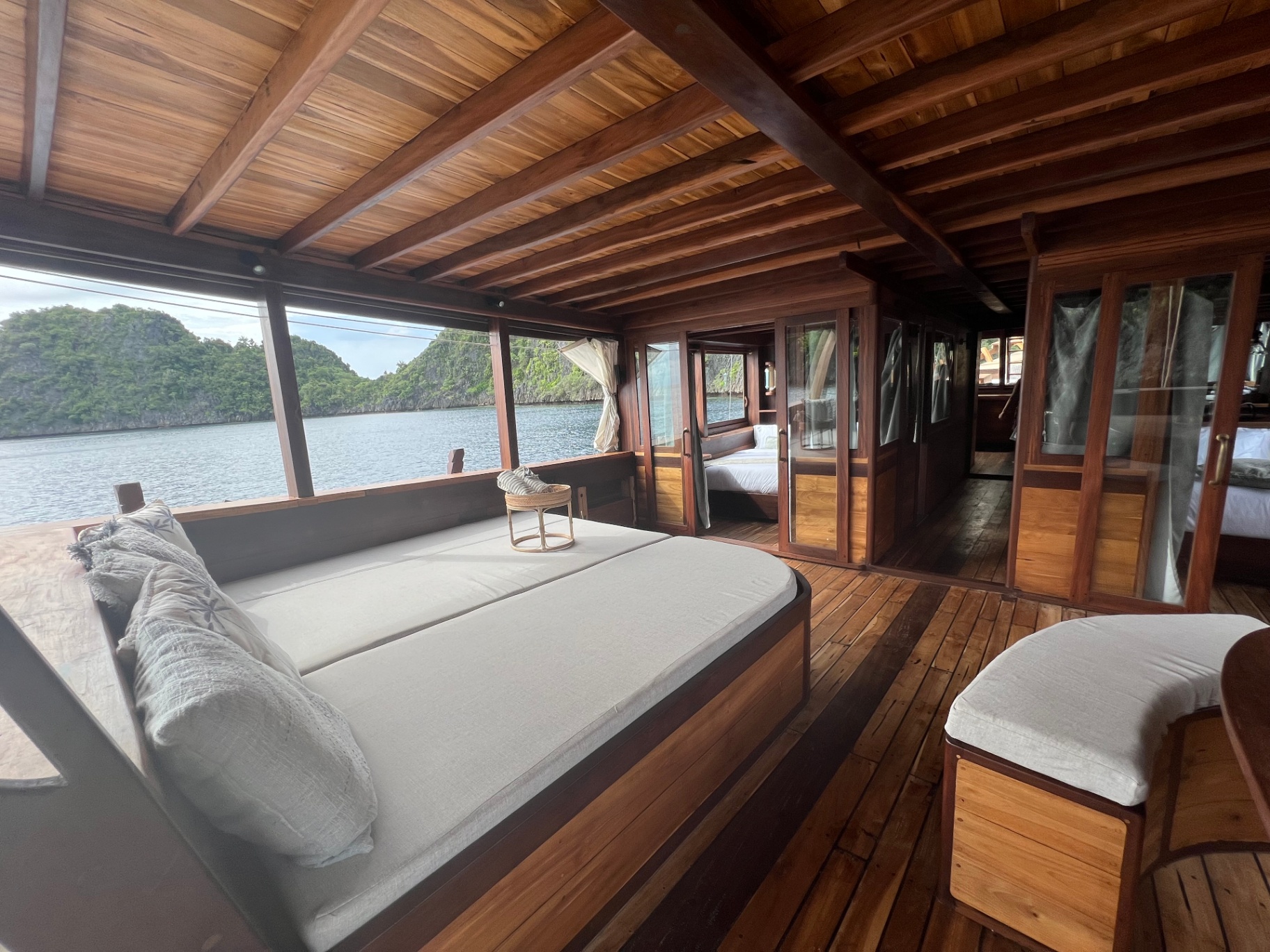 Dewata chill deck daybed with sliding cabin doors along the passageway