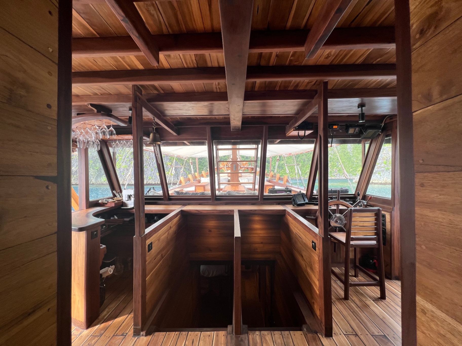 View from Dewata's foredeck through the wheelhouse toward the bow in a Raja Ampat cove