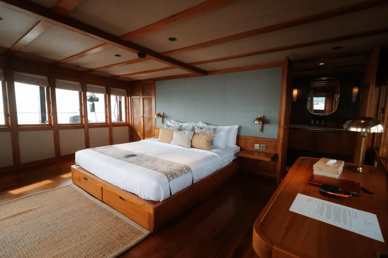 Celestia master stateroom with king bed, teak interior and writing desk