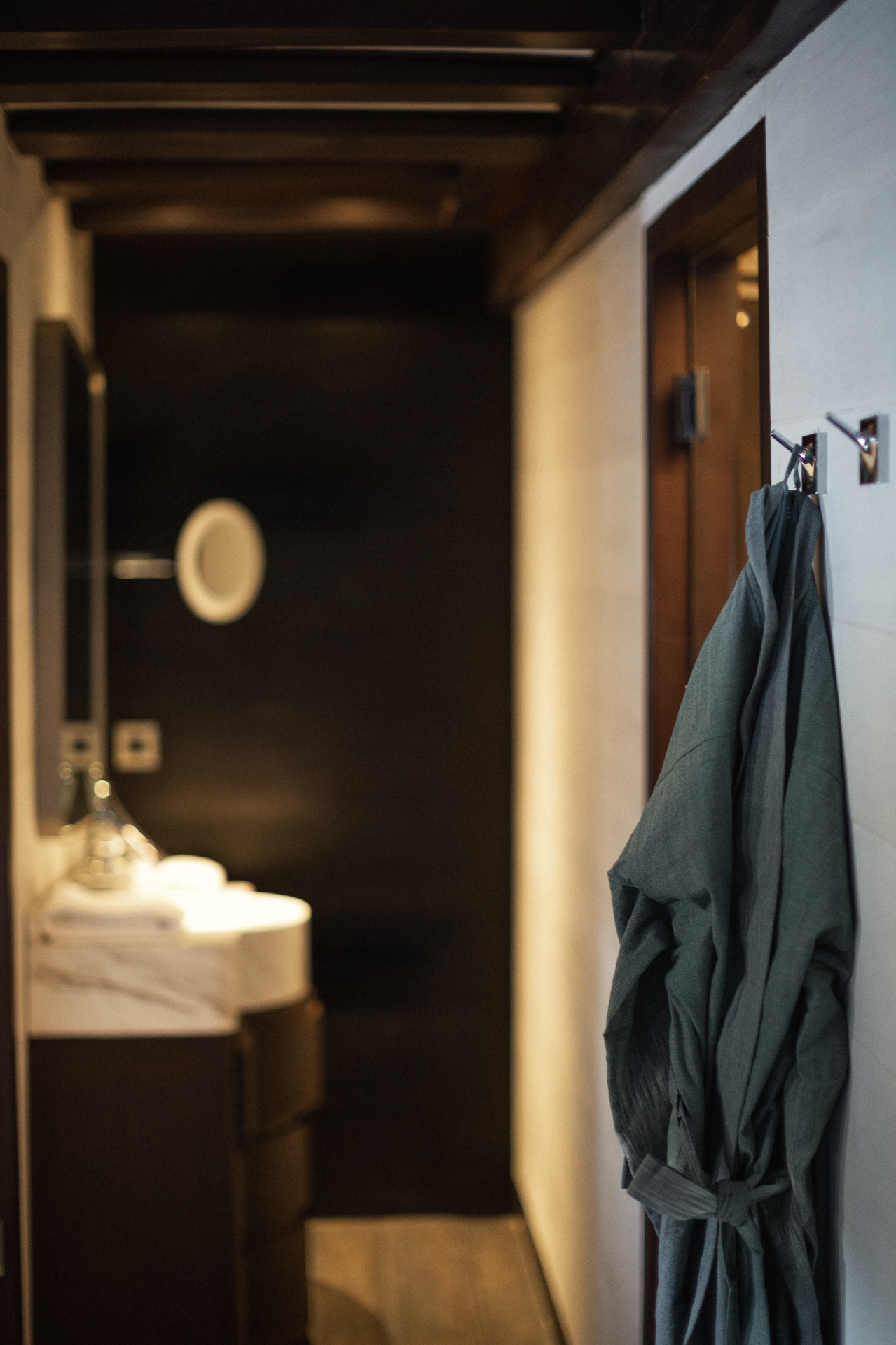 Vela stateroom en-suite entry with marble vanity, robe and dark timber beams