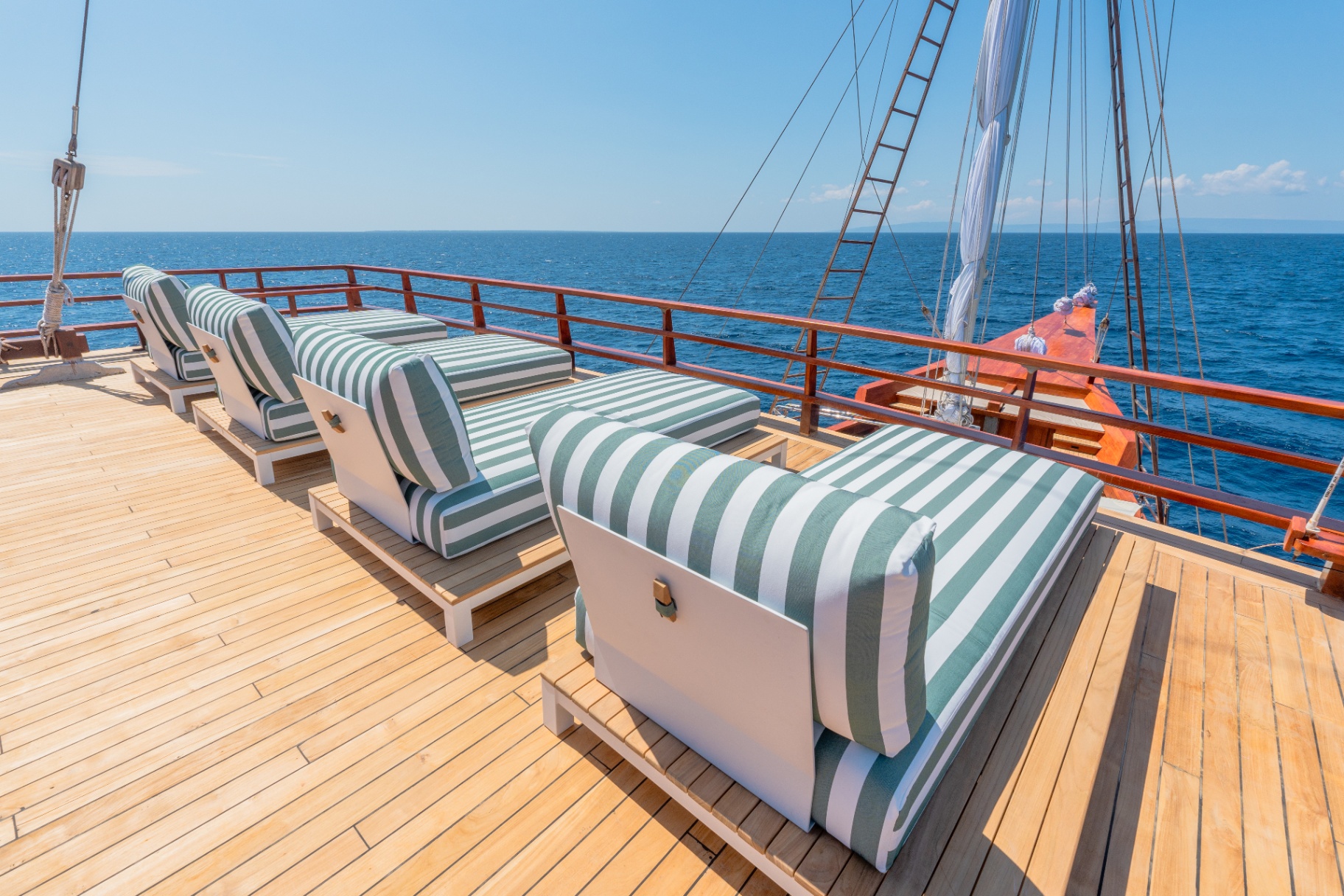 Row of green-striped sun loungers on Sanctuary's teak sundeck overlooking deep blue open sea