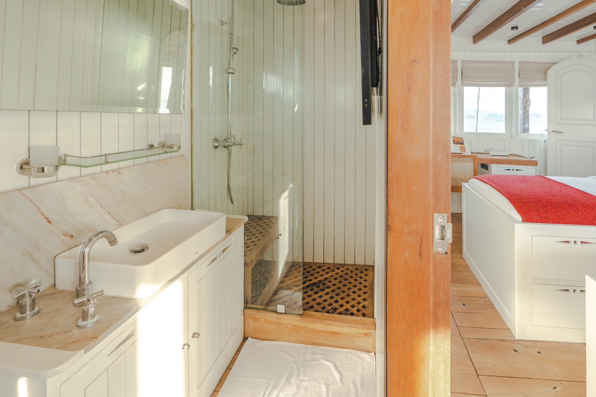 Banda cabin ensuite bathroom on Mischief with marble counter, vessel sink and glass-enclosed rain shower