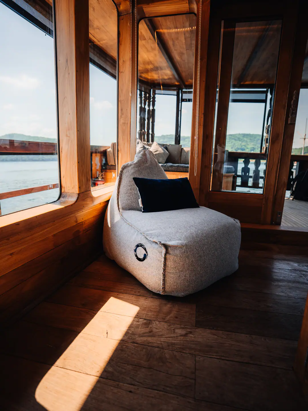 Reading nook on The Oracle with grey bean bag chair facing panoramic windows over the sea