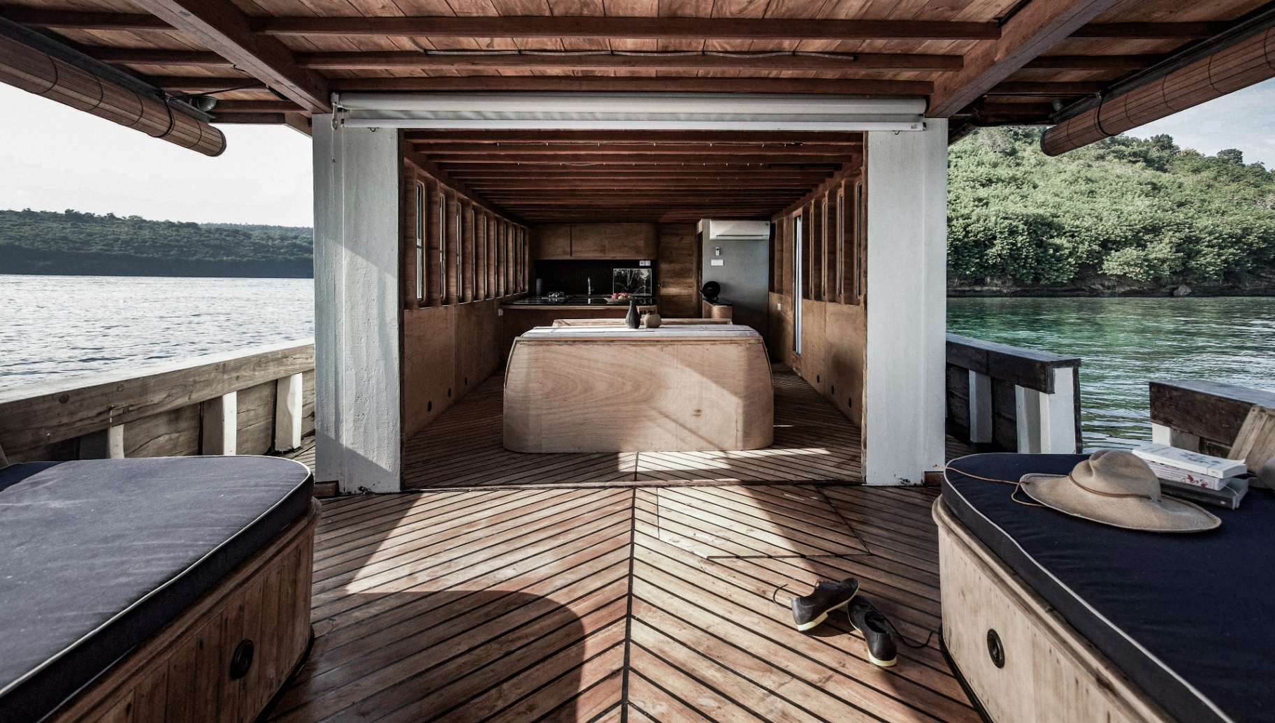 Symmetrical view across Splendour's aft deck into the interior lounge and galley framed by twin daybeds