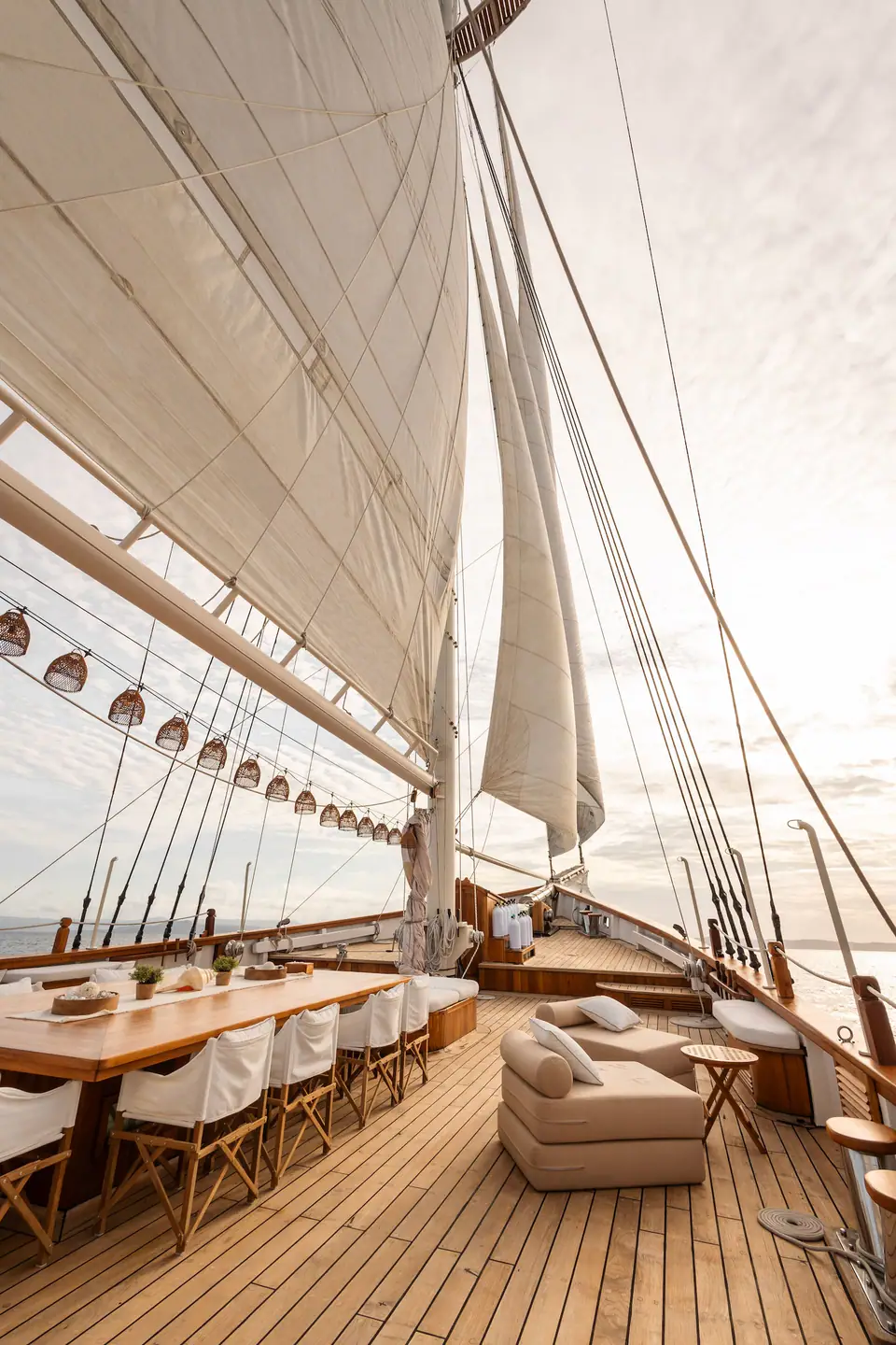 Mutiara Laut phinisi under full sail at golden hour — Raja Ampat private yacht charter
