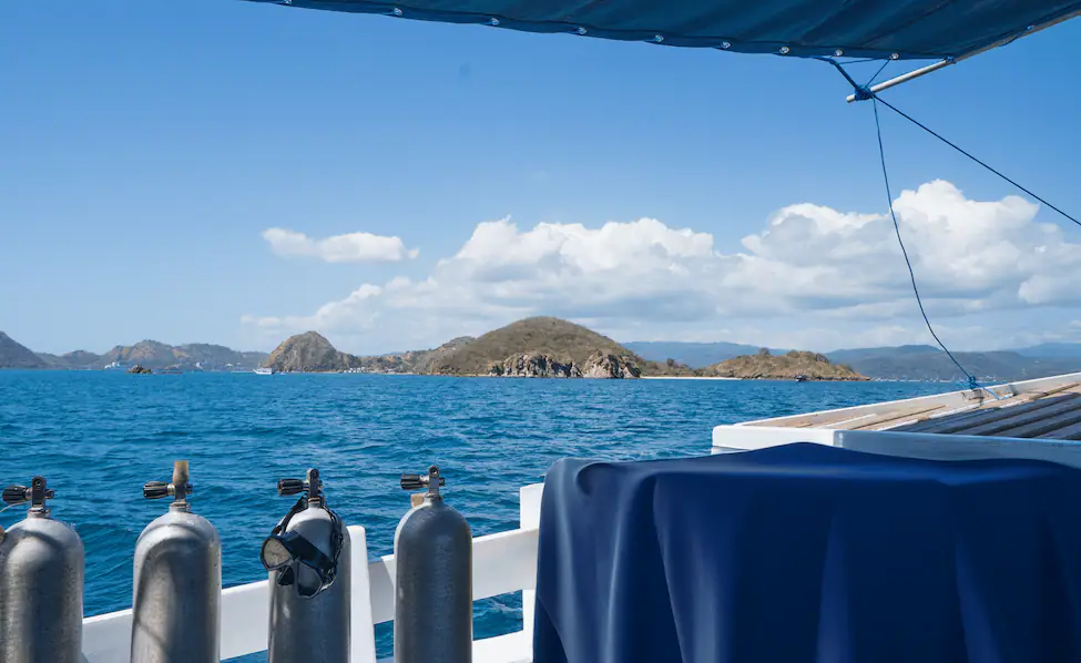 Dive tanks lined up on Jinggo Janggo's shaded dive deck overlooking Komodo islands