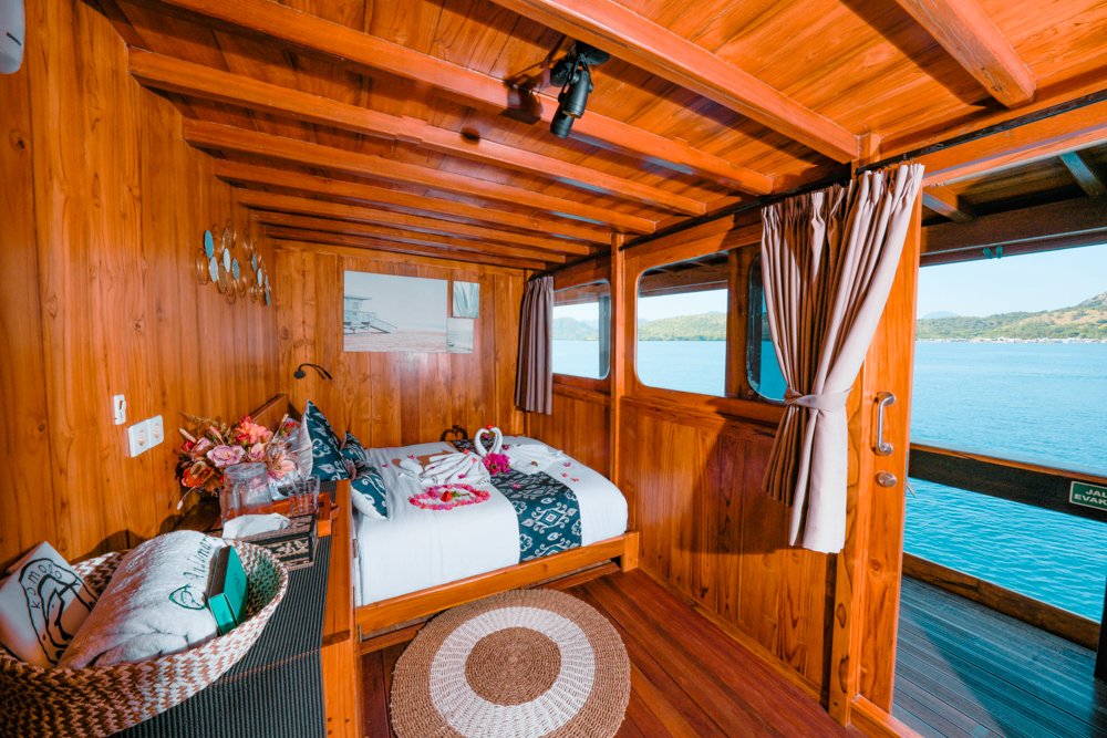 Andamari cabin with a double bed, large windows and direct sea views from the cabin doorway