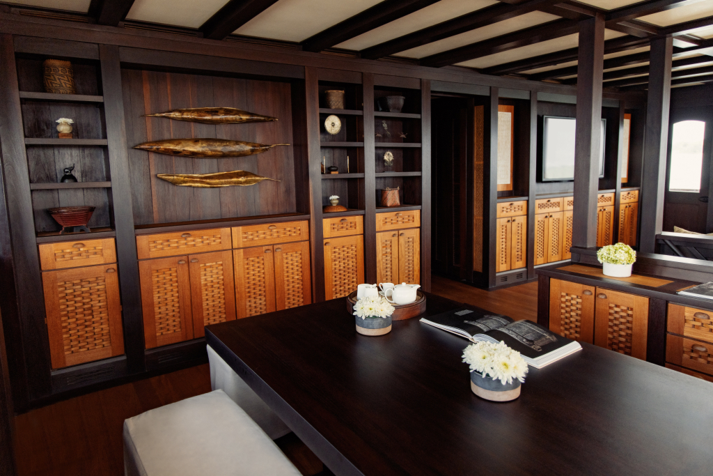 Interior salon with woven-cane cabinetry, carved sailfish artwork and reading table