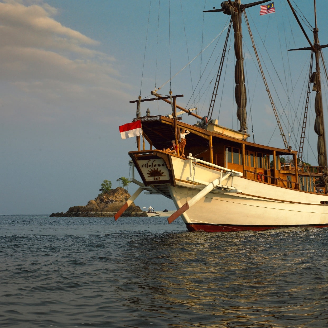 Silolona at golden hour with Indonesian flag flying from the bowsprit