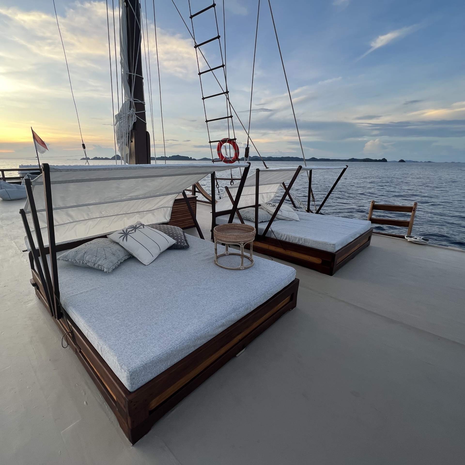 Twin sun loungers on Dewata's top deck at sunset with Indonesian flag flying
