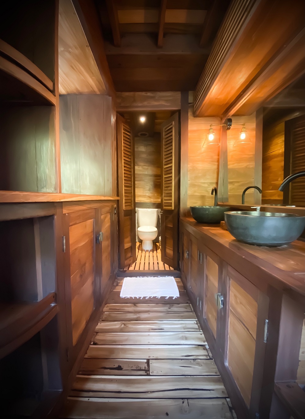 Master ensuite on Senja looking down the wooden corridor to the WC with basin vanity on the right