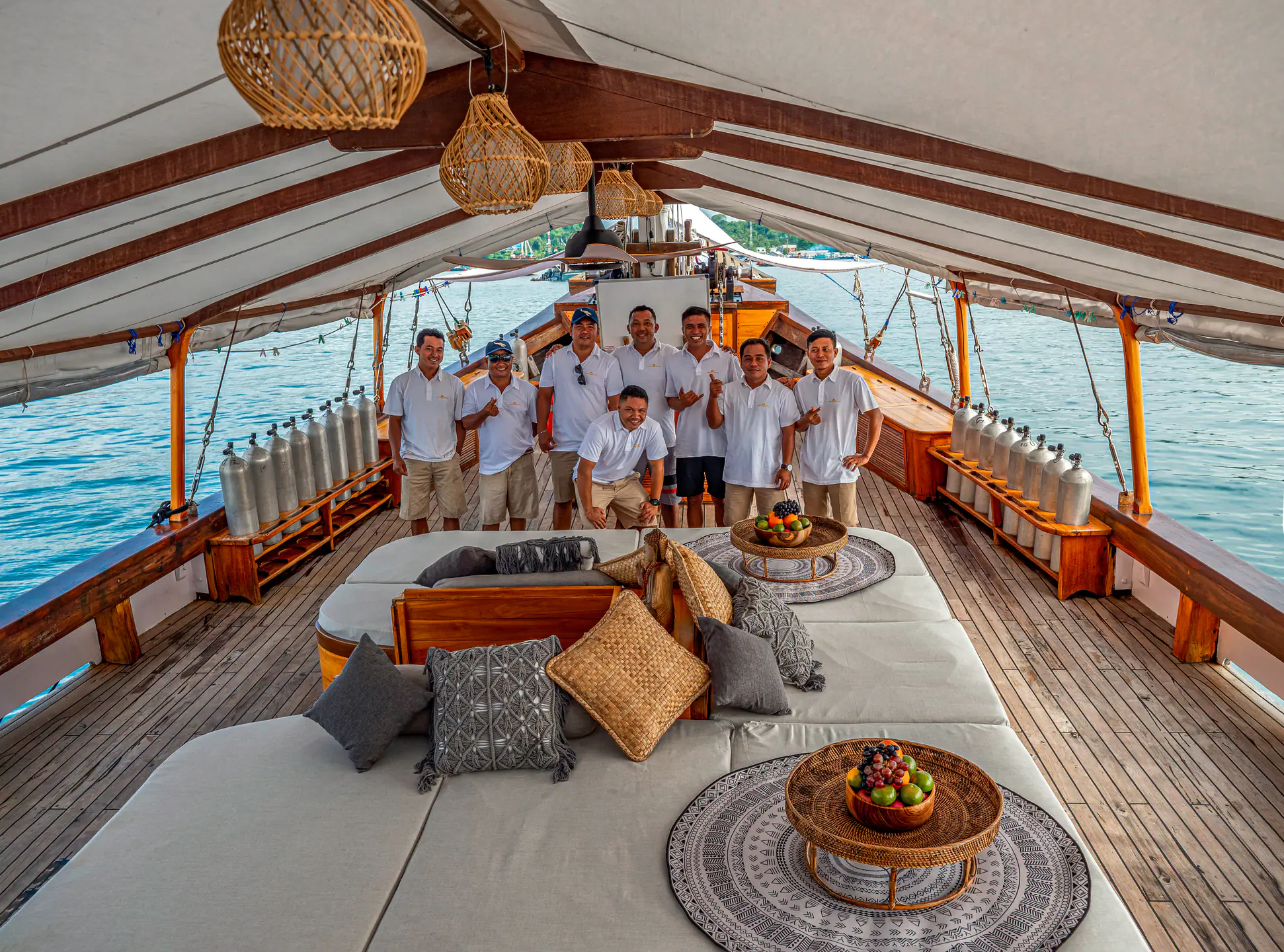 Anne Bonny crew standing between dive tanks on the main deck
