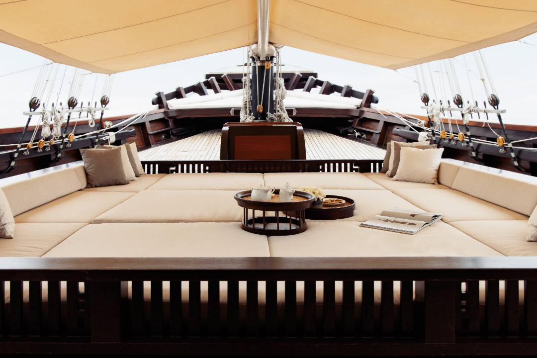 Shaded bow daybeds with cushions and tea service on Dunia Baru