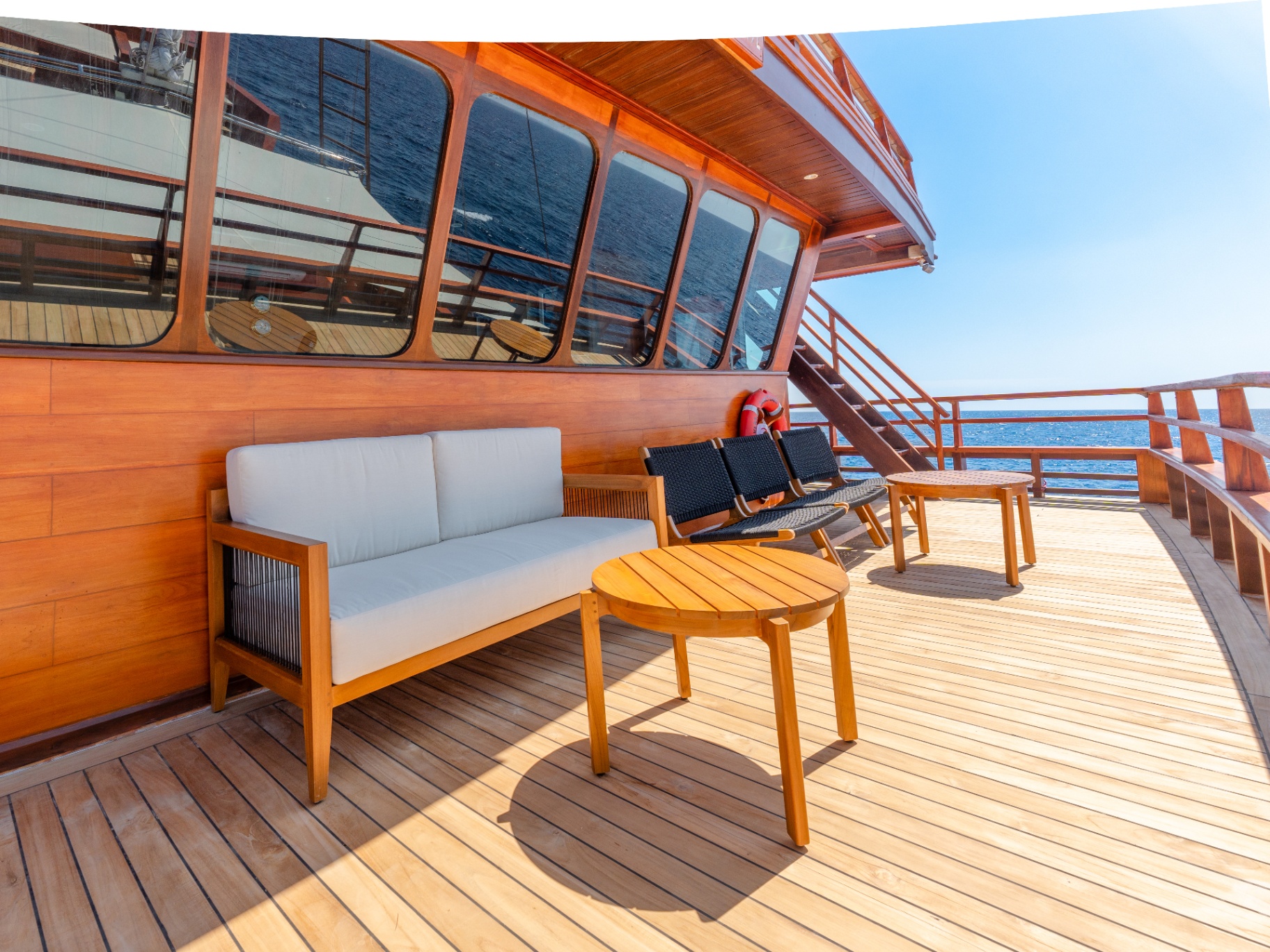 Shaded outdoor lounge on Sanctuary with teak sofa and armchairs beside the wheelhouse