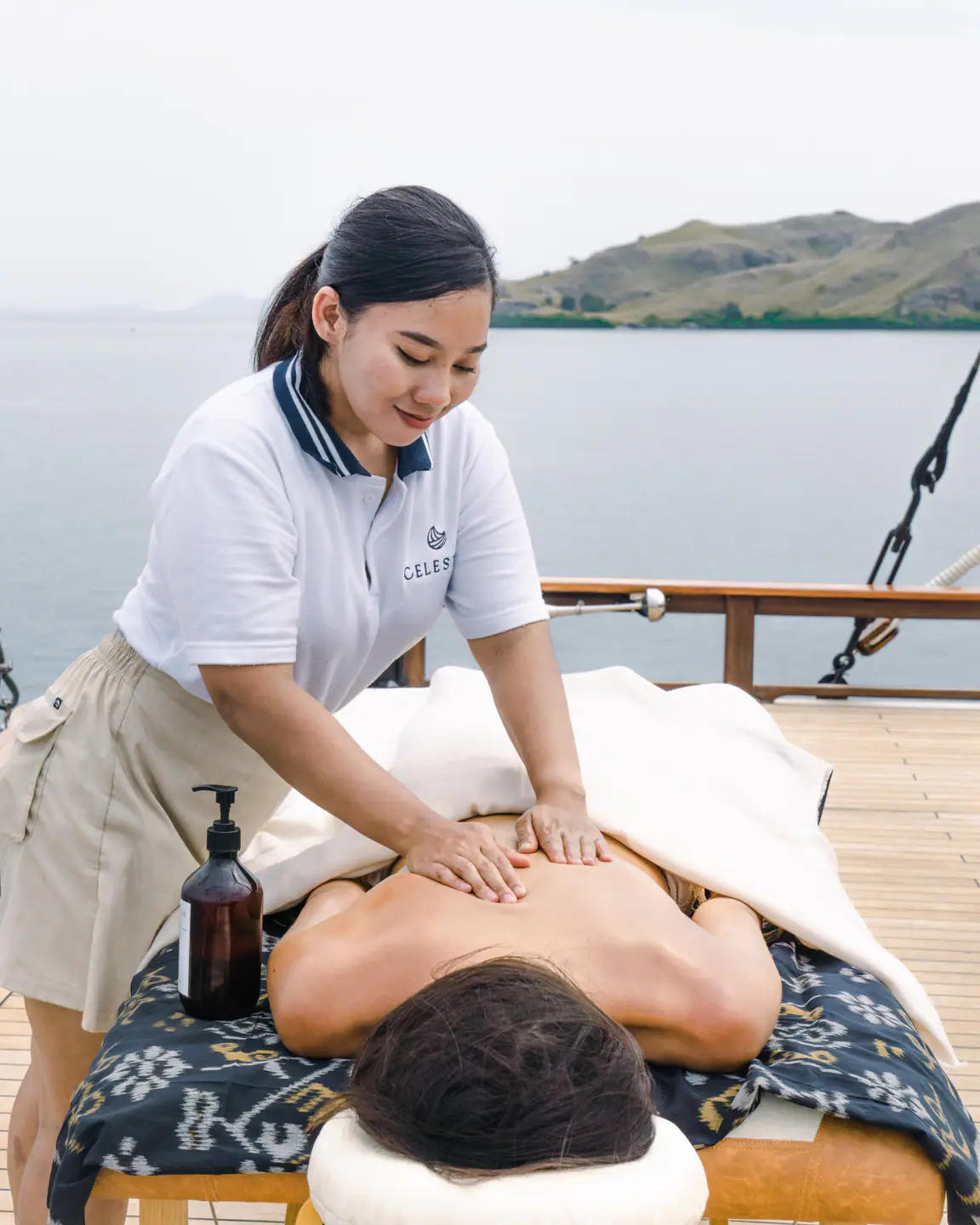 In-suite massage on Celestia's teak deck with sea view, Raja Ampat
