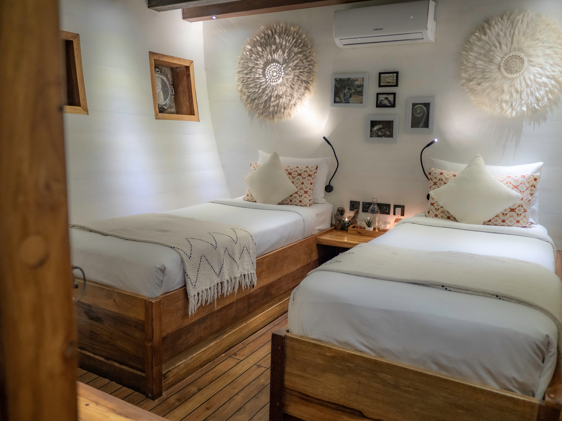 Twin cabin on Fenides with two beds, feather wall art and porthole