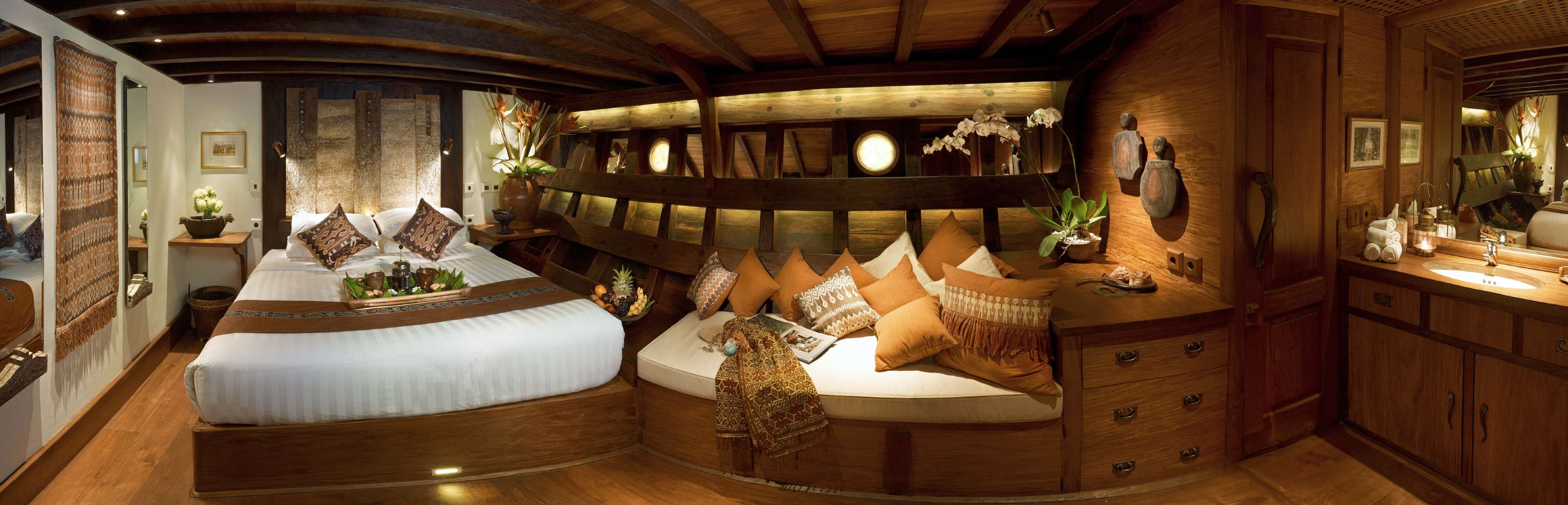Toraja Suite on Si Datu Bua with queen bed, carved timber walls and traditional Sulawesi textiles