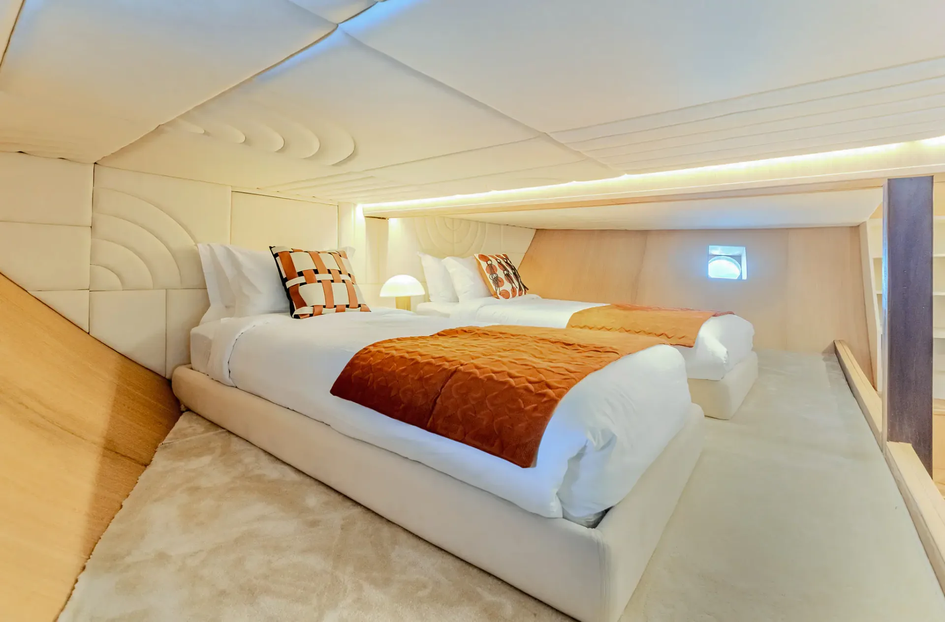 Twin-bed guest cabin on Kayra with quilted headboards and warm accent lighting