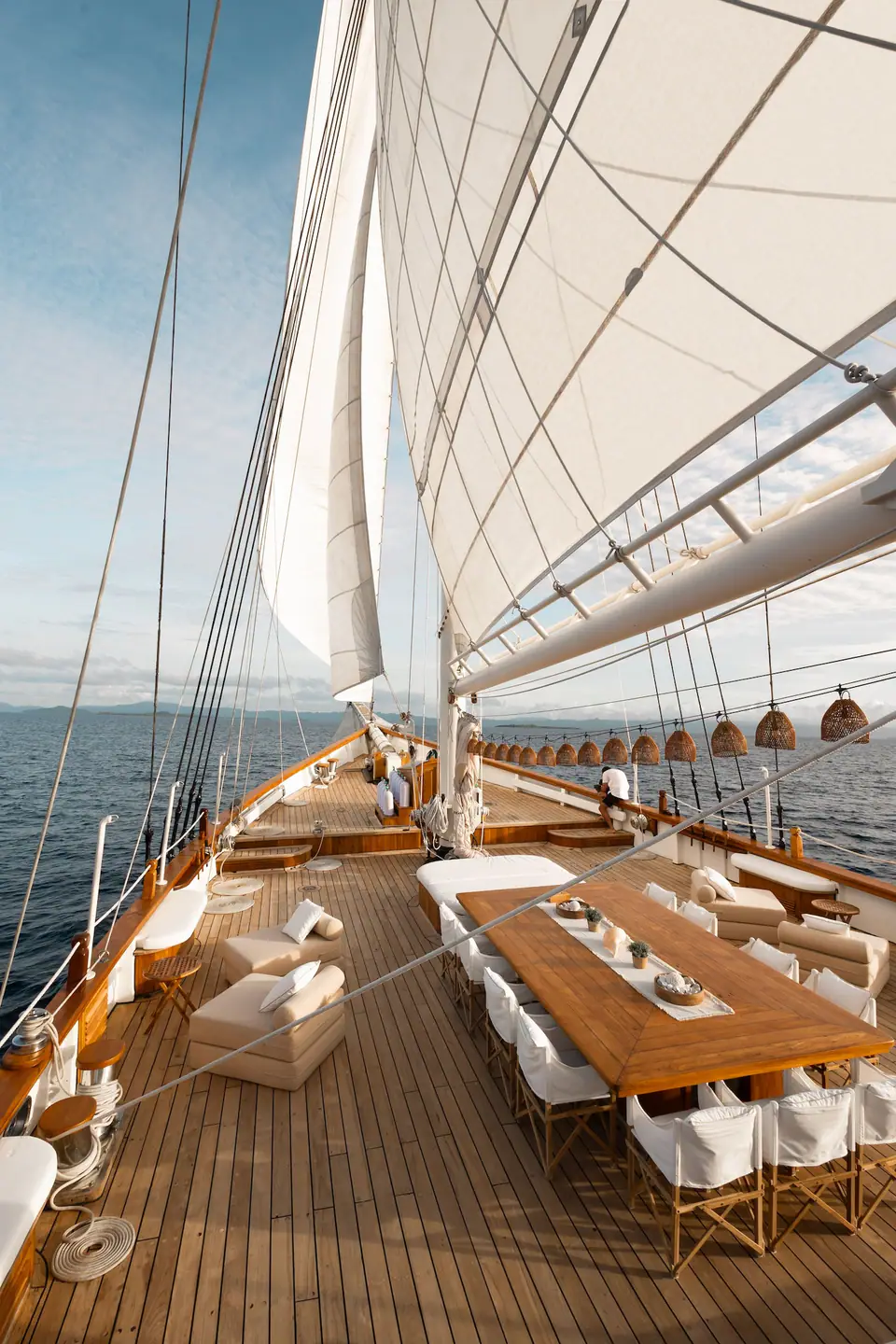 Mutiara Laut main deck view forward while sailing, sails set against blue sky