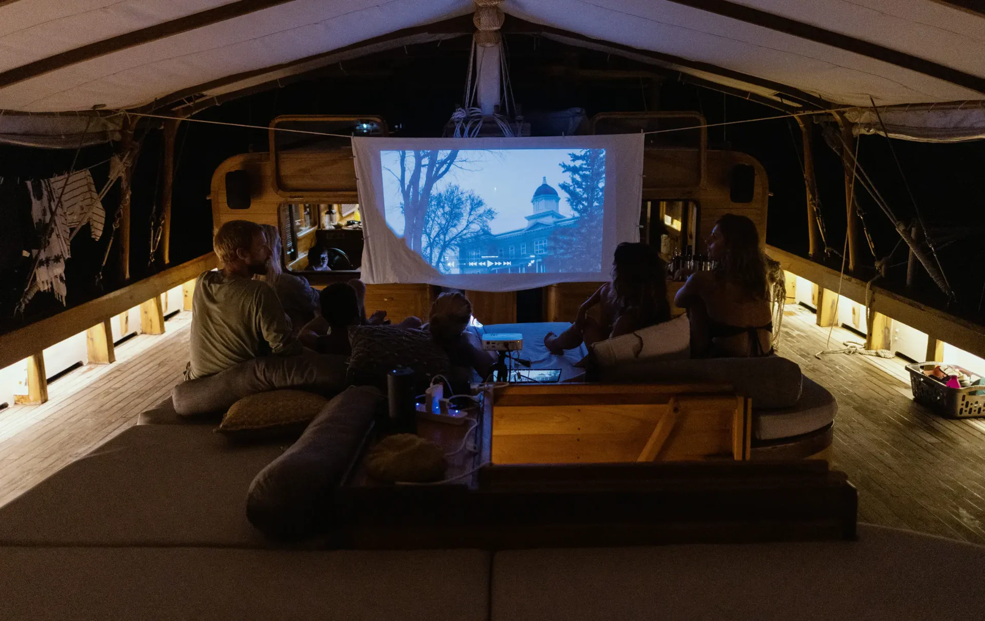 Guests watching an outdoor movie projected on deck aboard Anne Bonny
