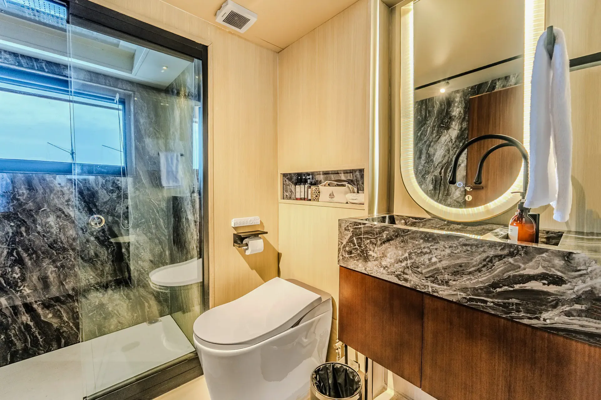 VIP ensuite bathroom with marble walls, glass shower and sea view