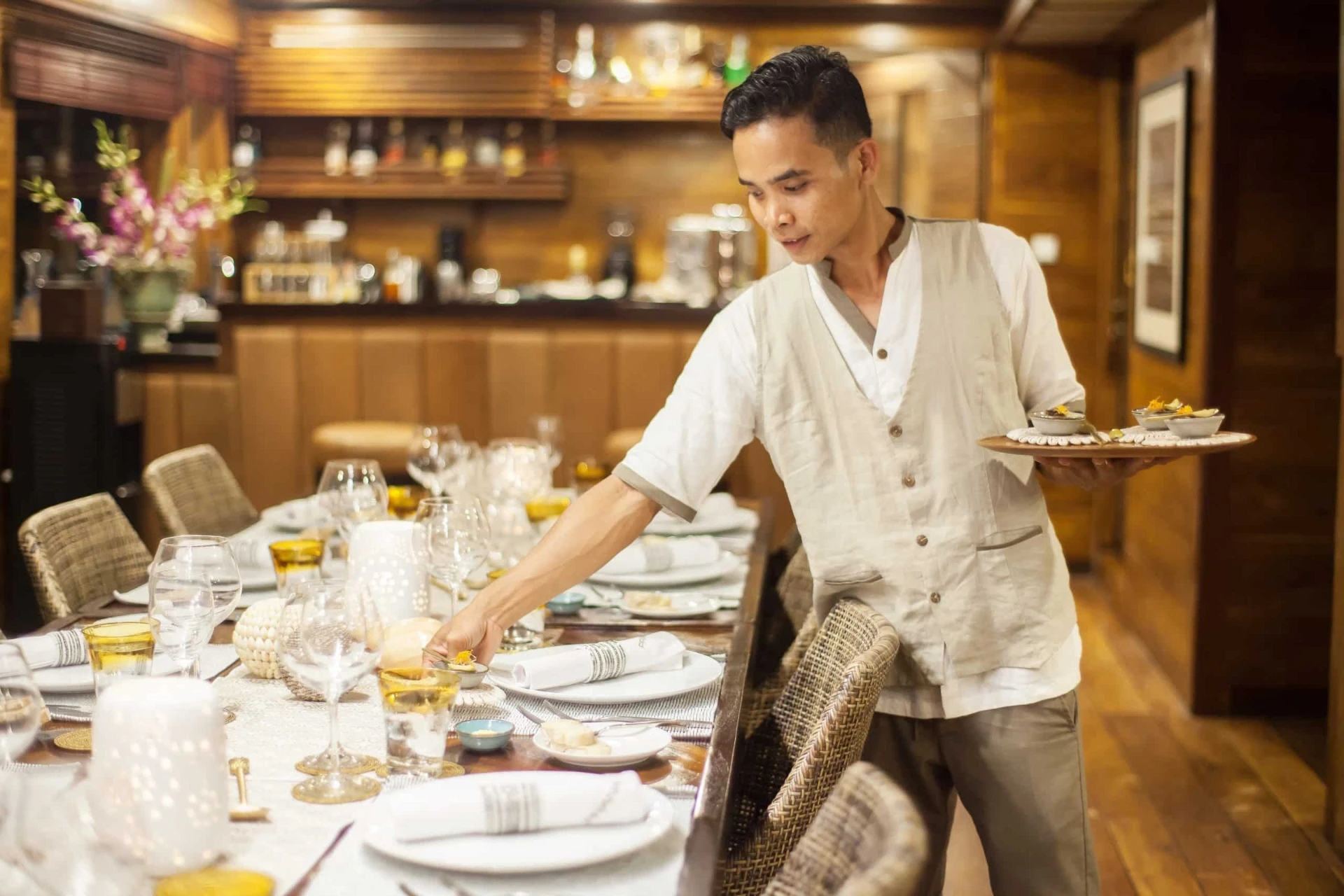 Prana by Atzaró crew plating a candlelit dinner in the indoor dining salon