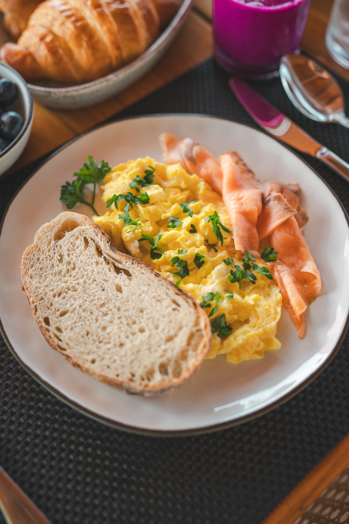 Plated breakfast with soft scrambled eggs, smoked salmon and rustic sourdough aboard Mischief