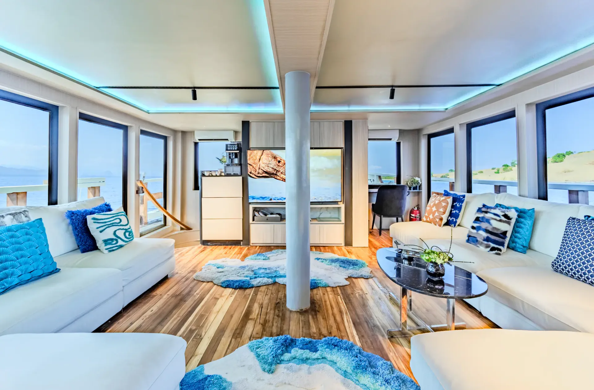 Panoramic salon on Kayra with wraparound windows, wave rugs and blue accent lighting