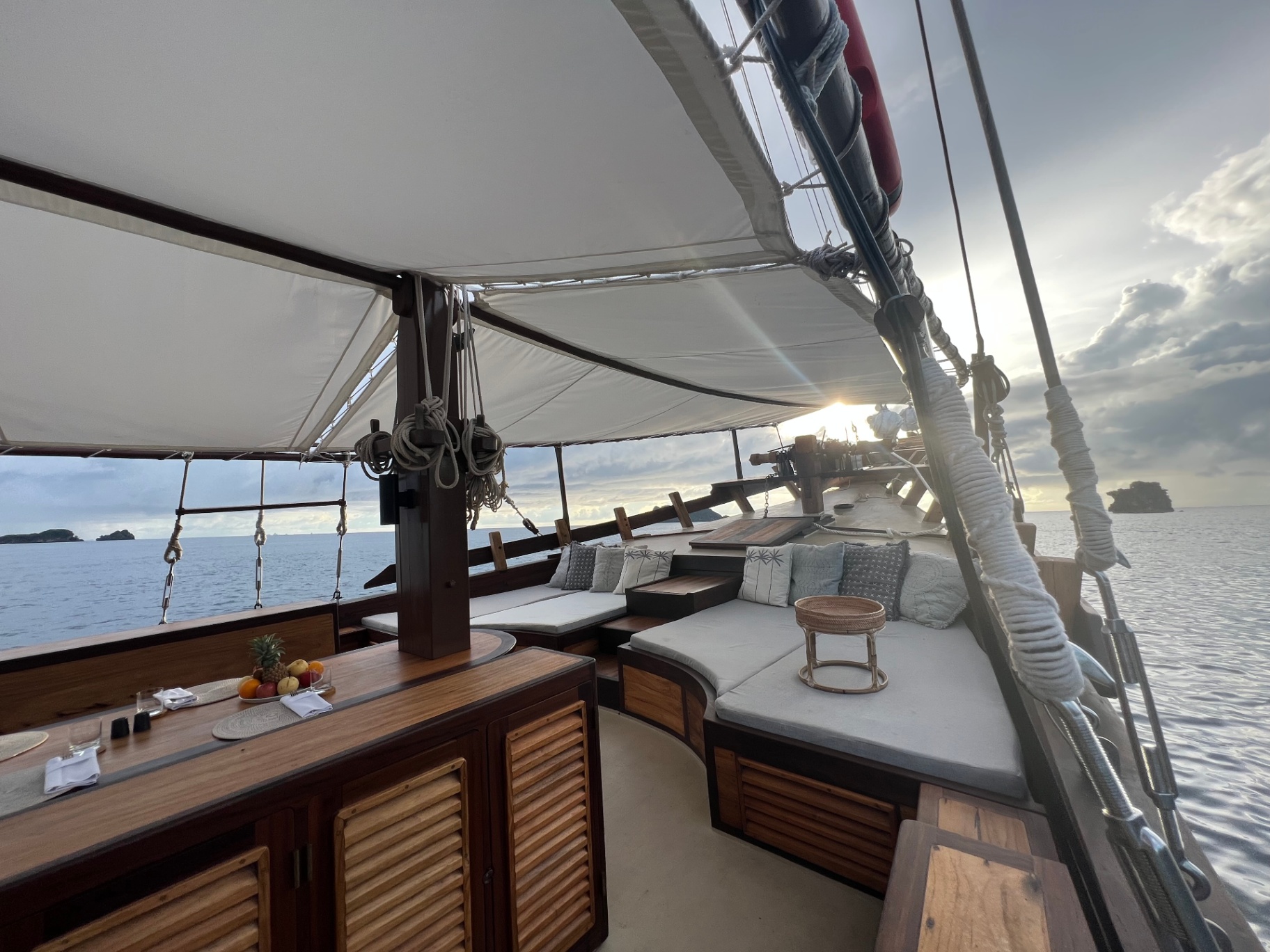 Dewata shaded lounge and dining area on the top deck at golden hour