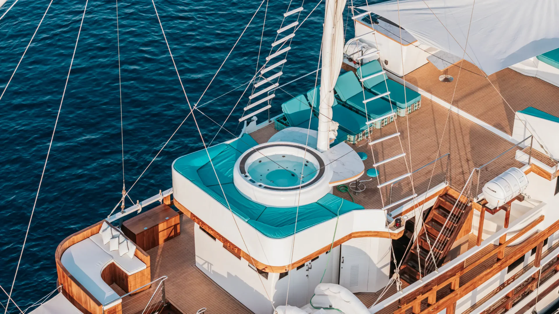Top deck of Kayra Phinisi with jacuzzi and sun loungers over the sea