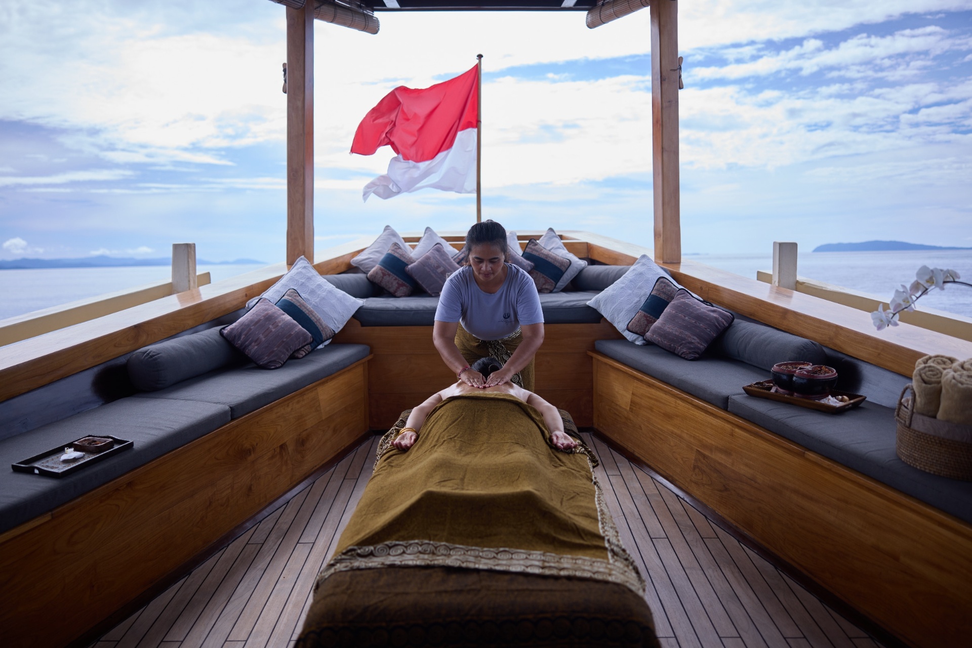On-deck massage under a canopy on Silolona with the Indonesian flag flying overhead