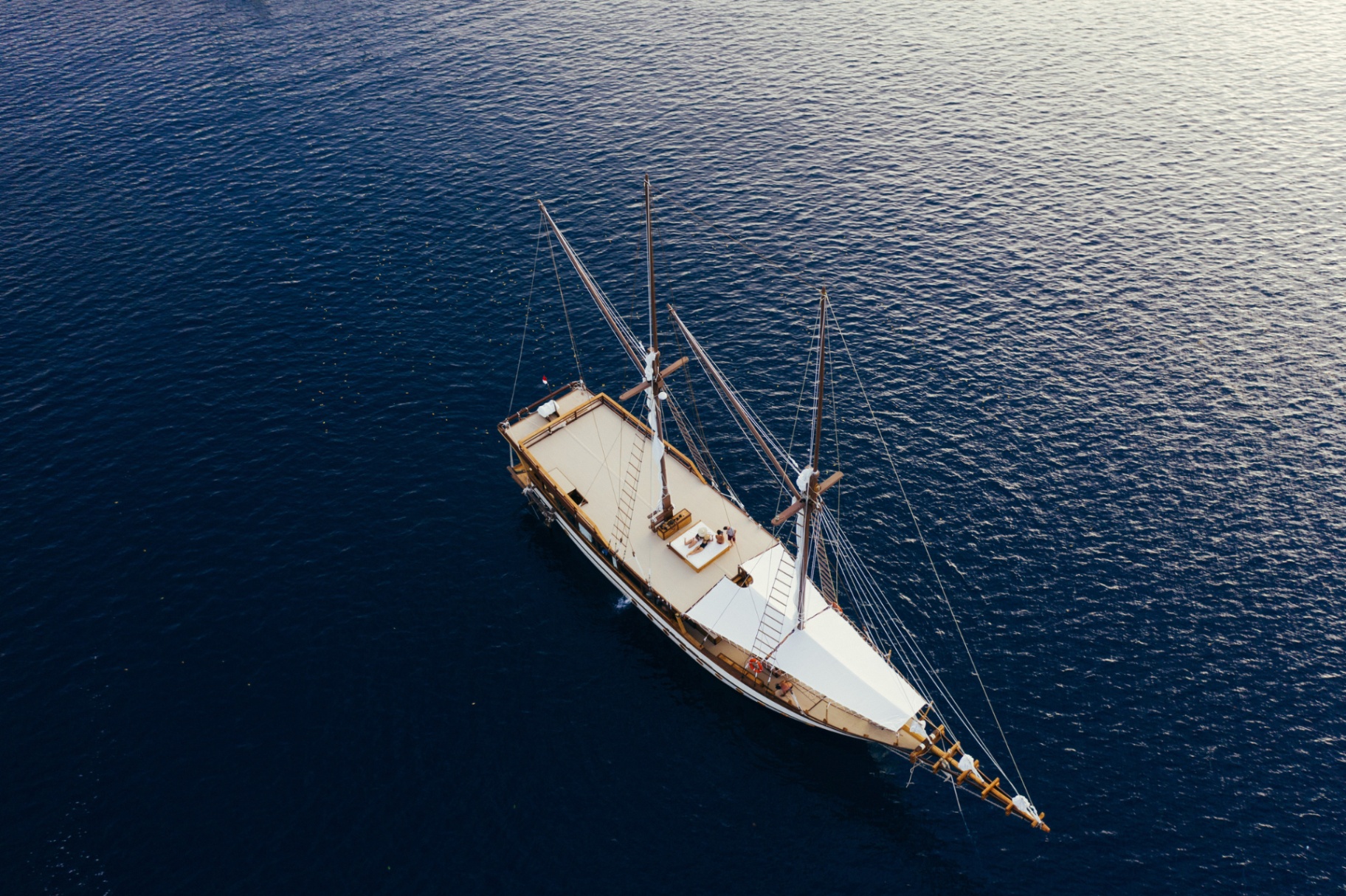 Aerial bow-quarter view of Senja on glassy dark blue water