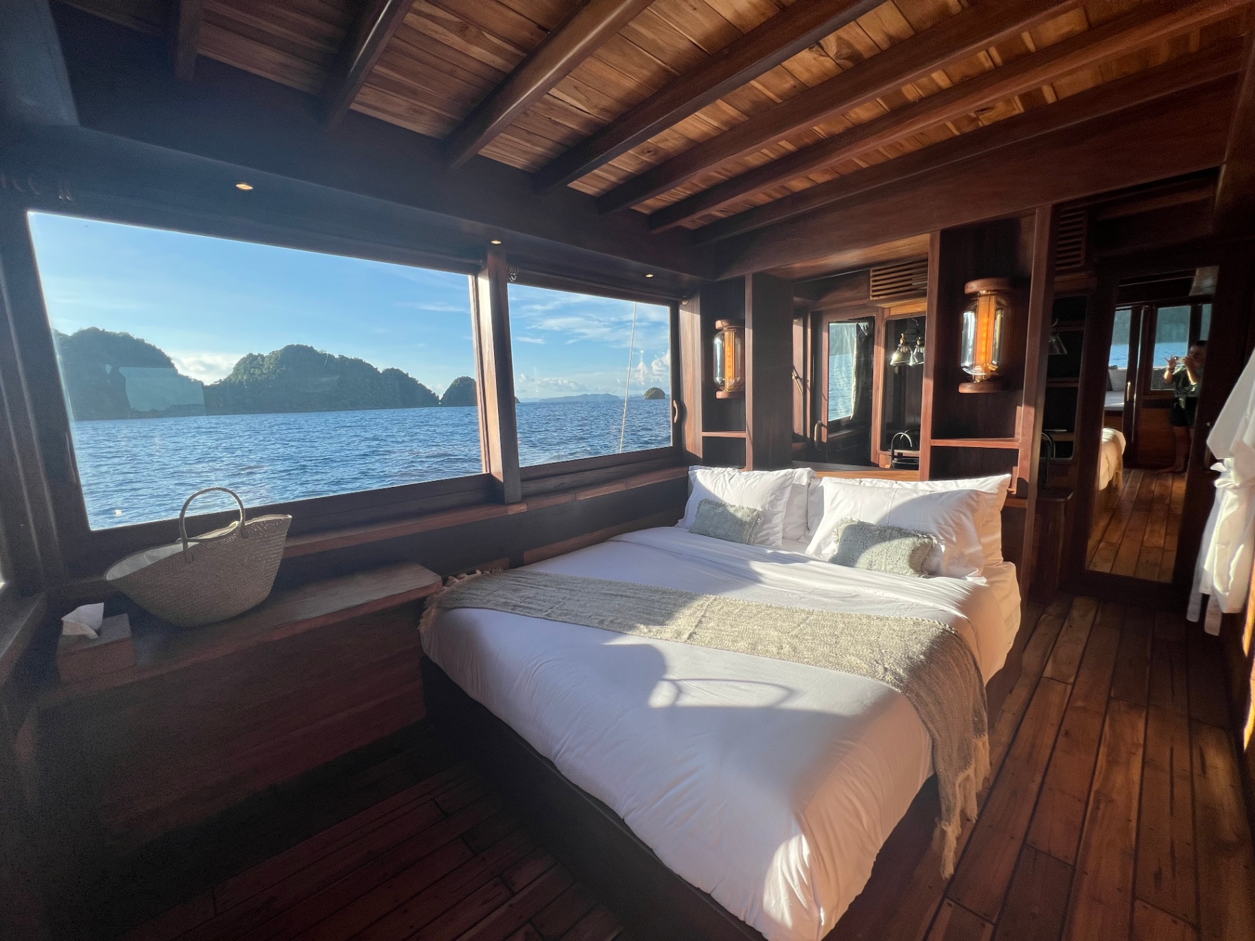 Golden afternoon light in Dewata's master cabin with king bed and sea window