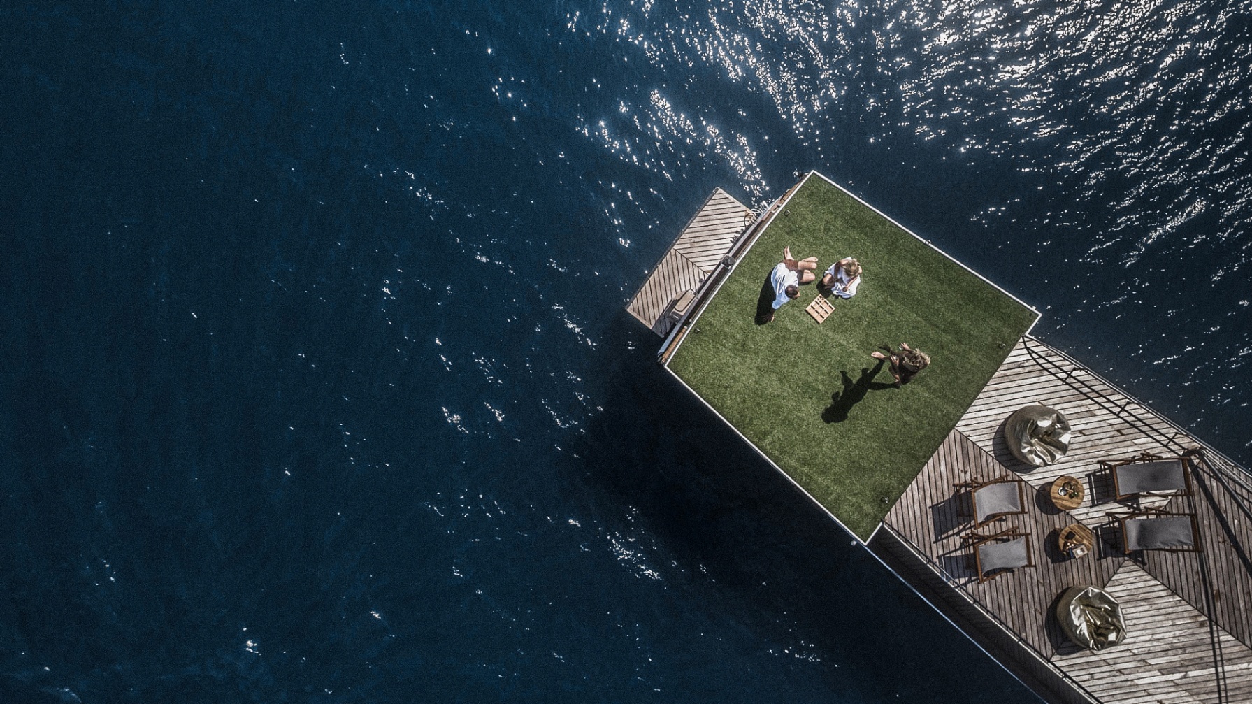 Overhead view of guests on Splendour's stern platform with deck chairs and open blue sea around them
