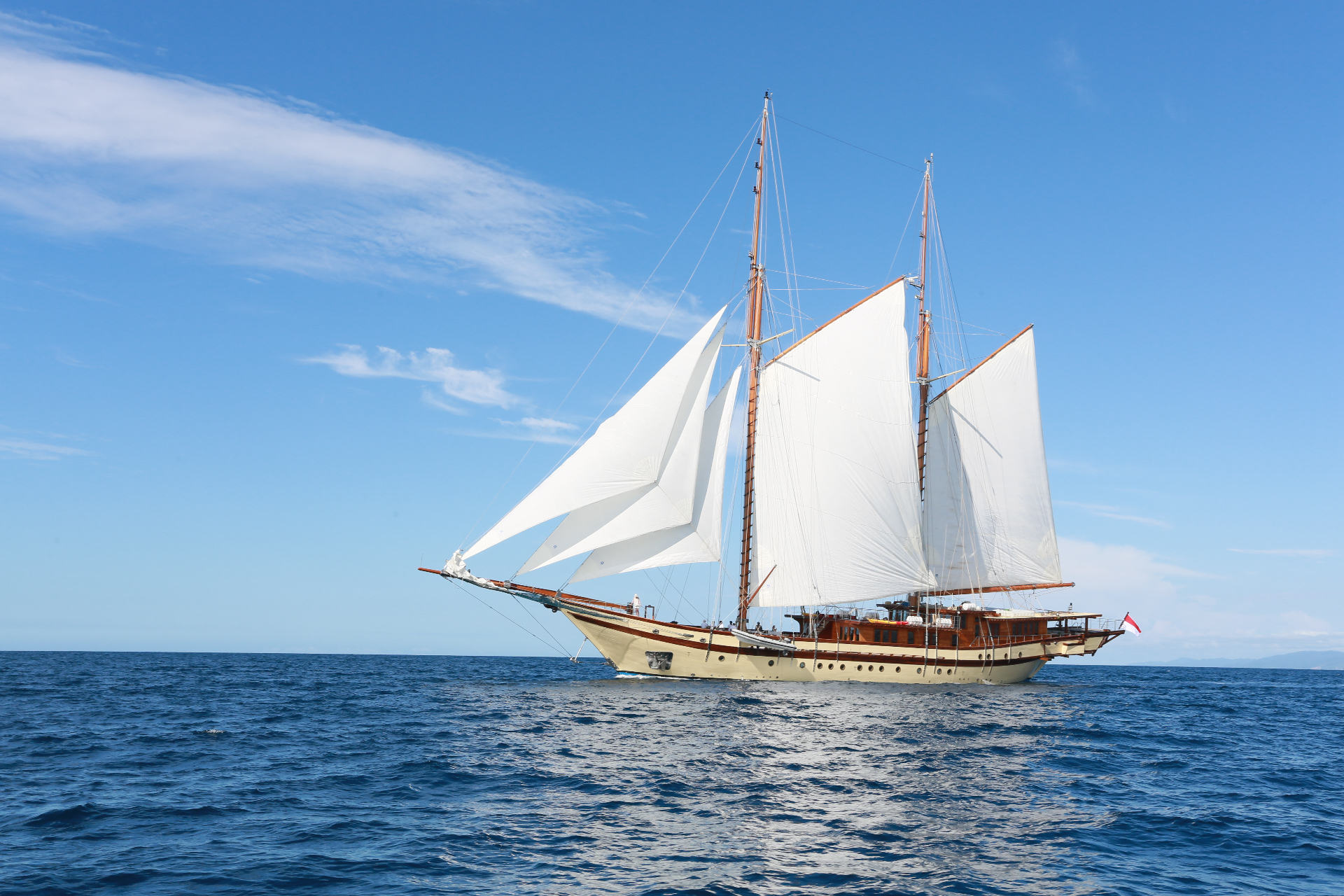 Lamima broadside under sail with Indonesian flag flying