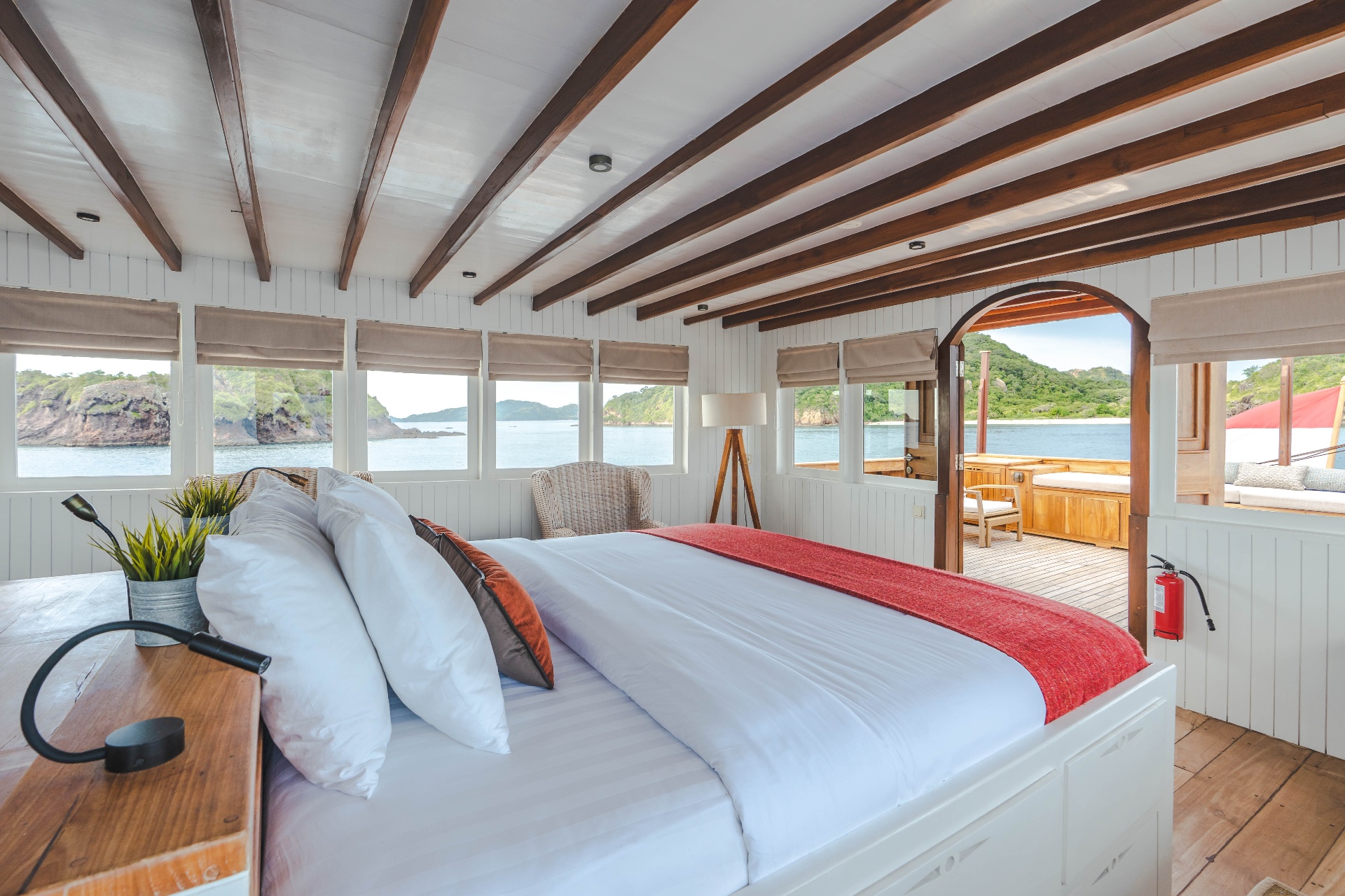 Komodo suite on Mischief with king bed, panoramic windows and open door to the outer deck lounge