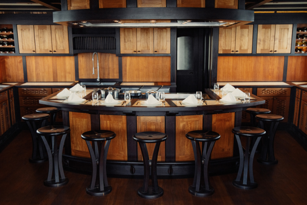 Curved teppanyaki bar with stools around a chef's cooking station
