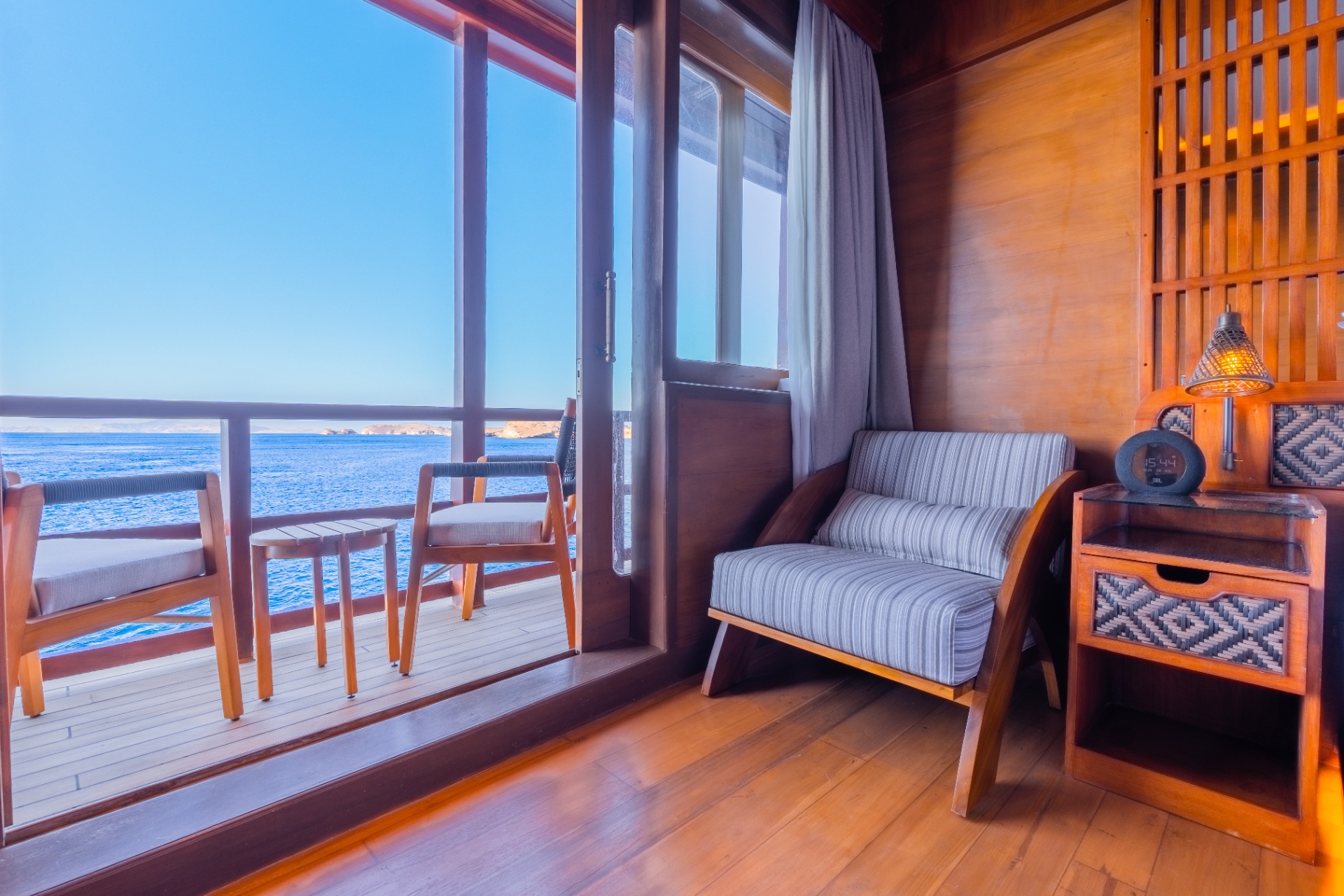 Deluxe cabin lounge chair beside a private balcony on Sanctuary looking out to Raja Ampat's blue water