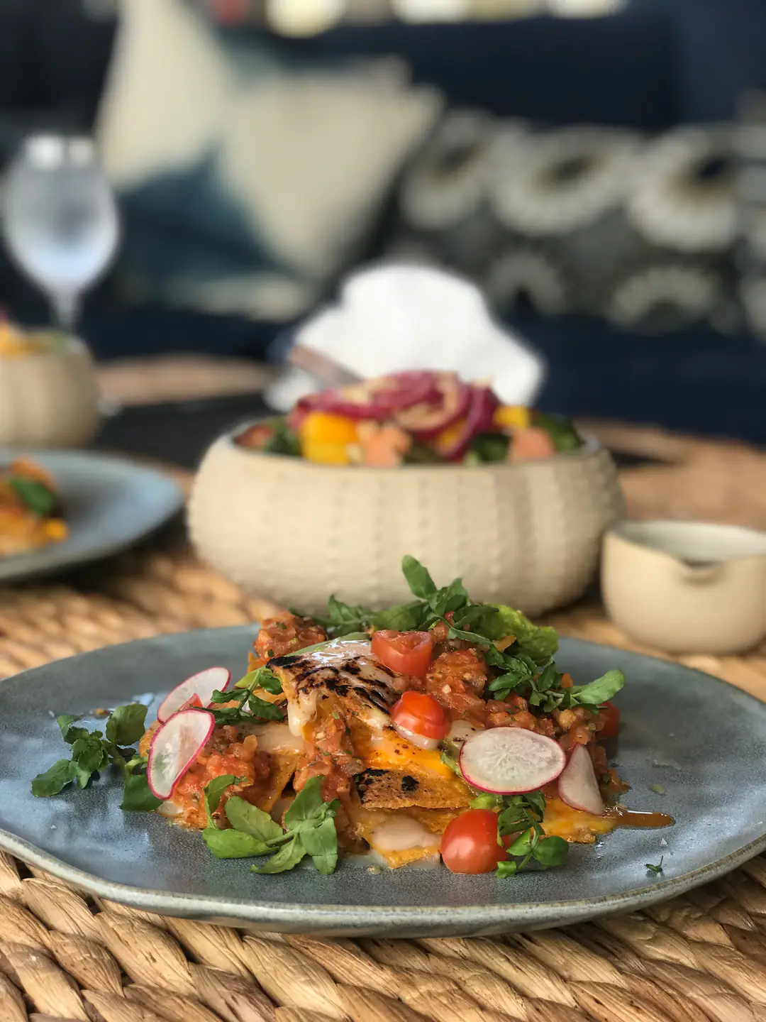 Plated chef's dish with grilled fish, tomato salsa, radish and herbs on The Oracle