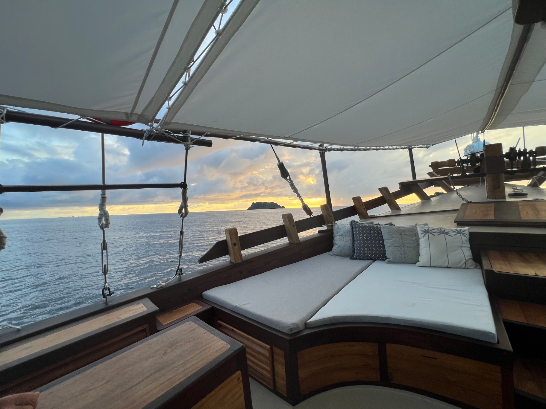 Sunrise view from Dewata's foredeck daybed with distant island on the horizon