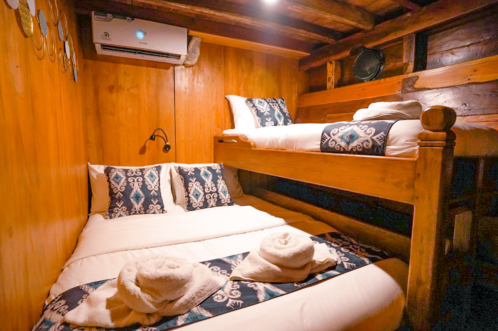 Twin bunk cabin on Adishree with ikat cushions on lower double and upper single bunks