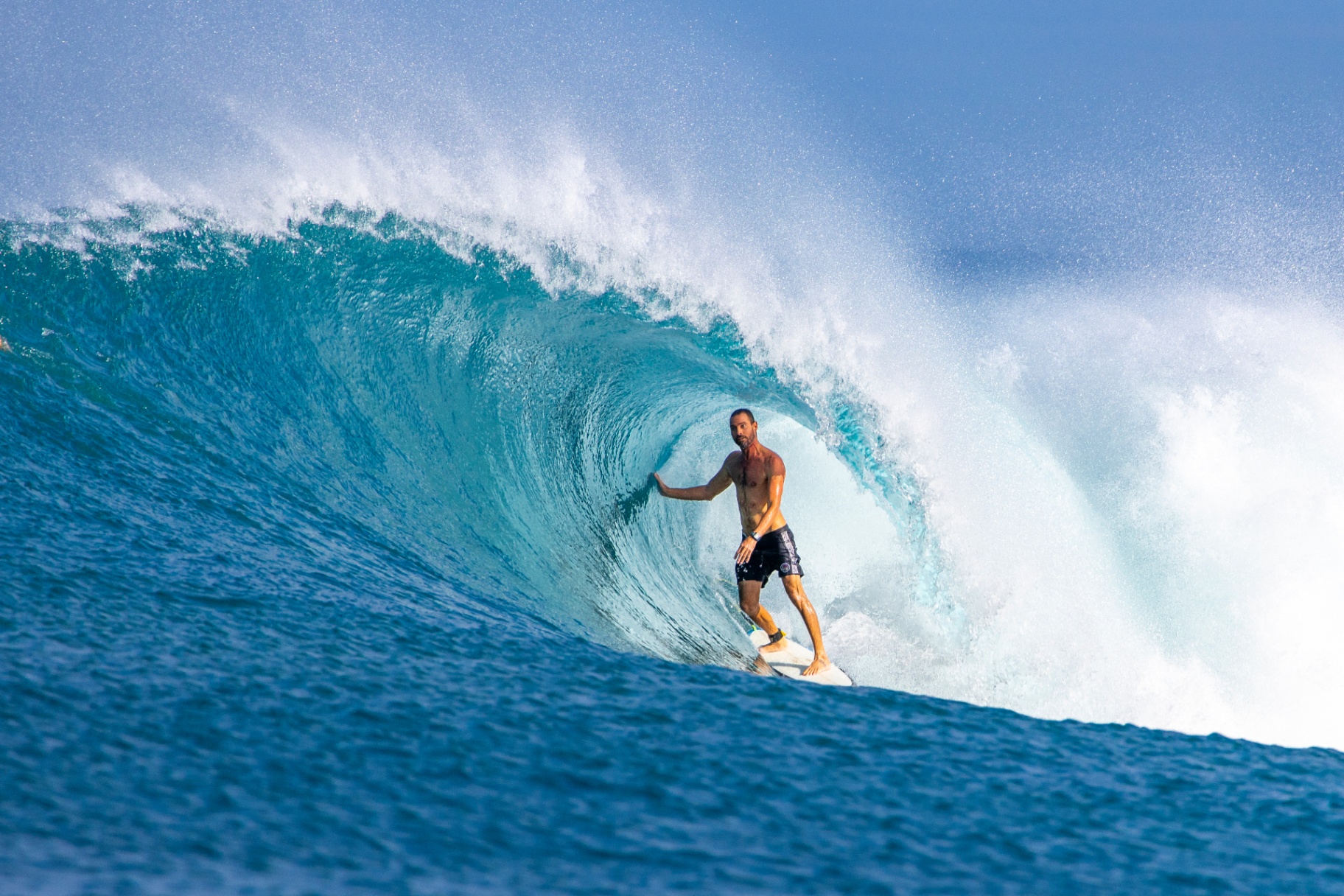 Surfer inside a large barrel wave during a Fenides surf charter