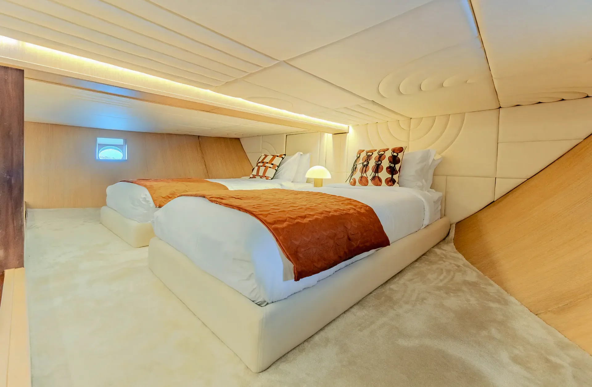 Twin guest cabin on Kayra with porthole window and orange throws
