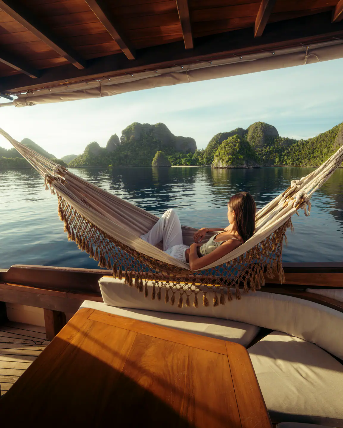 Guest relaxing in a hammock aboard Anne Bonny in Raja Ampat