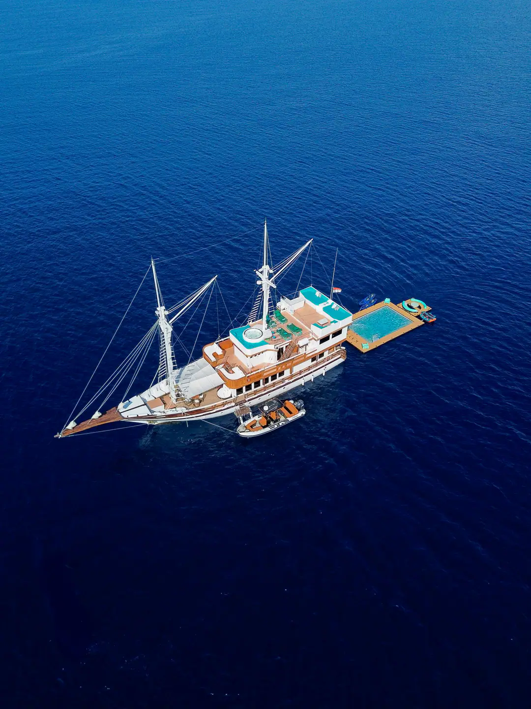 Aerial of Kayra Phinisi with floating pool deck rigged alongside