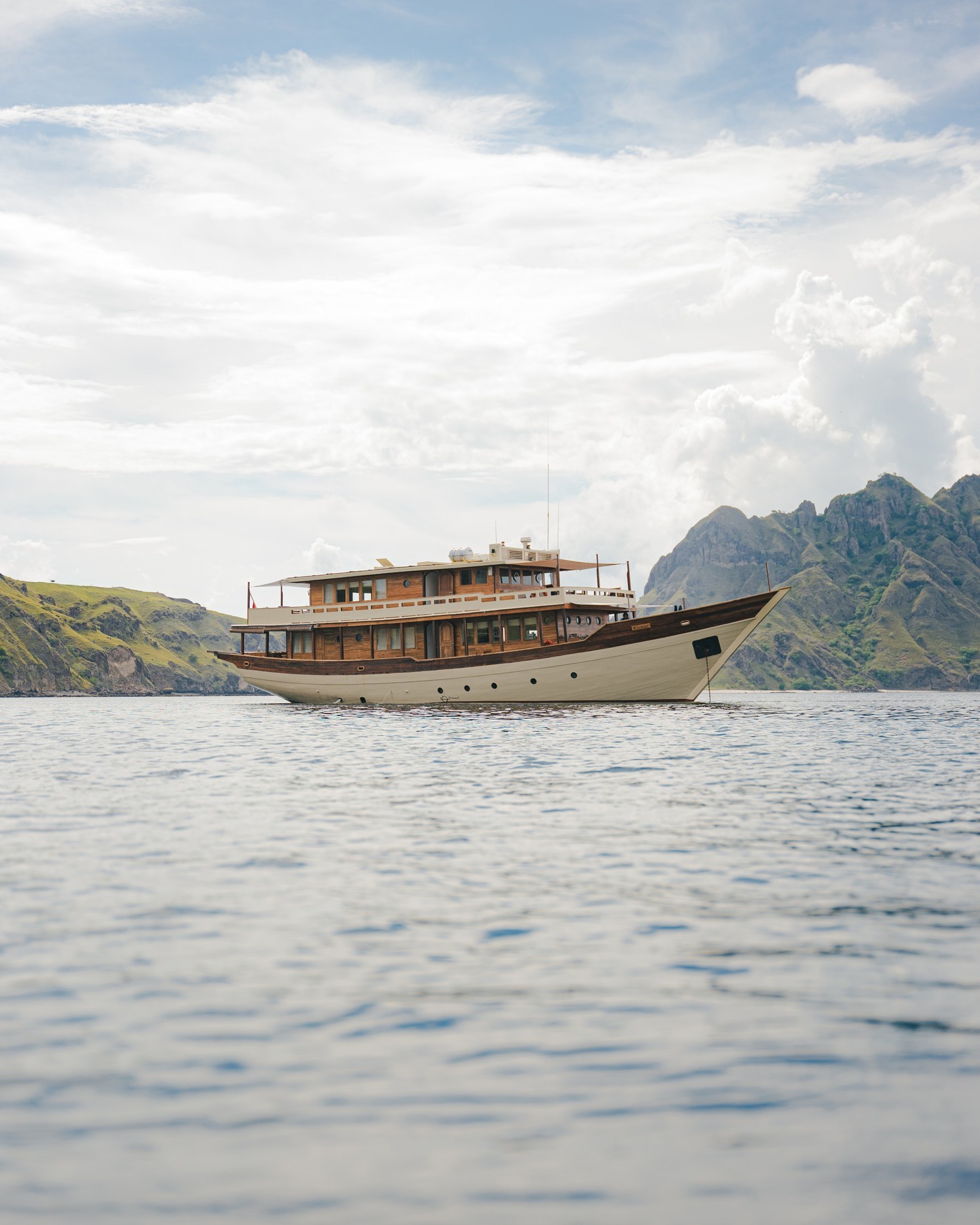 Side profile of Mischief against the jagged peaks of Padar Island