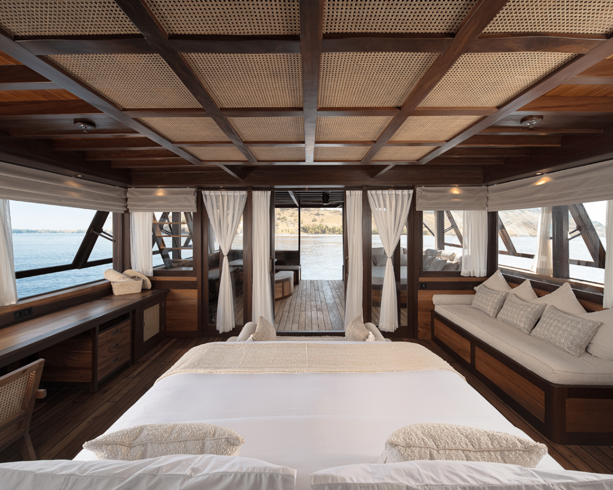 Sanya master cabin with rattan ceiling panels, king bed and terrace beyond