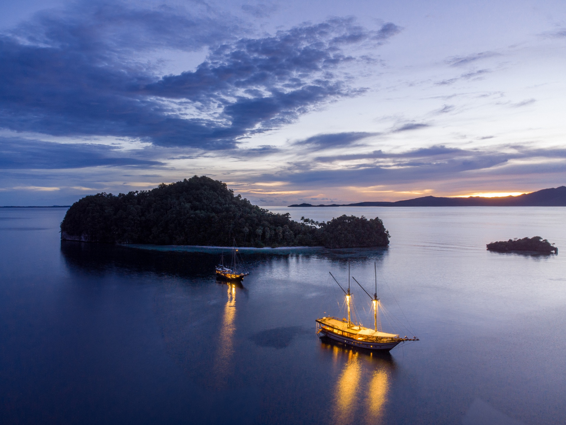 Senja glowing warm against a purple twilight sky beside a small jungle island