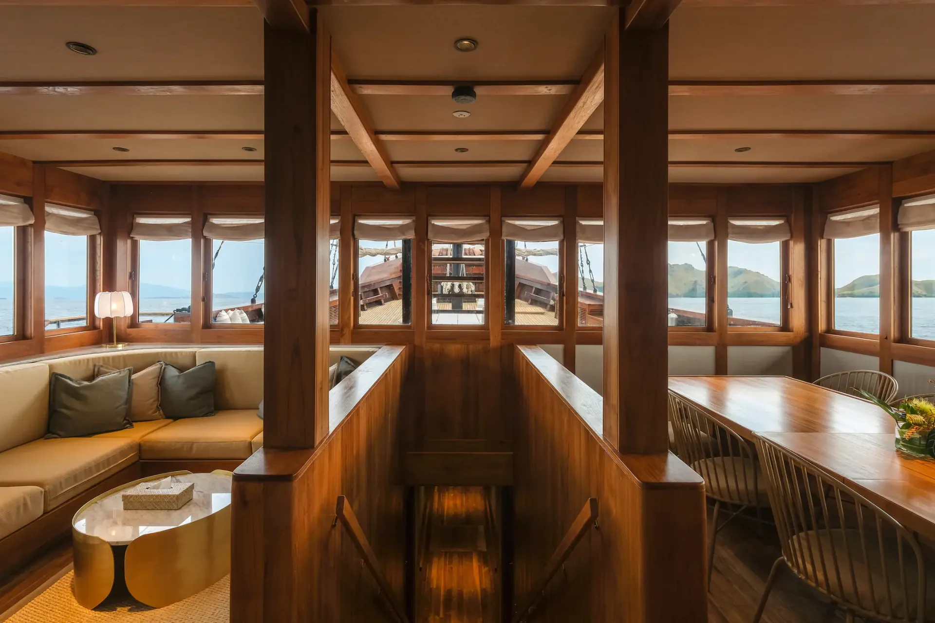 Celestia main salon with teak beams and panoramic windows over Raja Ampat